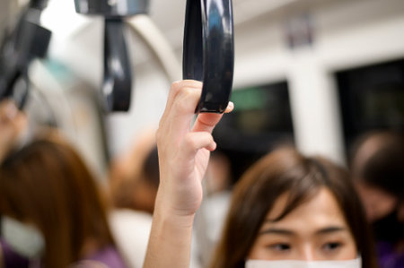 A close up of woman hand holding hand rail in public transportation (metro, sky train)