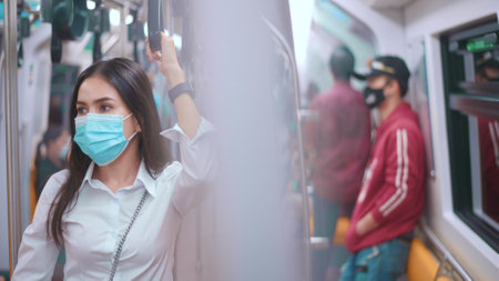 A young business woman is wearing face mask in public transportation , safety travelの写真素材