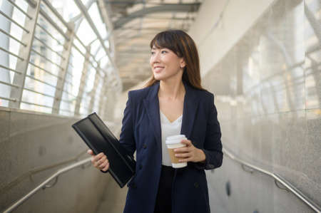 Portrait of beautiful young asian business woman is working in modern city