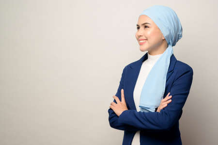 A close up of young beautiful muslim businesswoman with hijab isolated on white background studioの写真素材