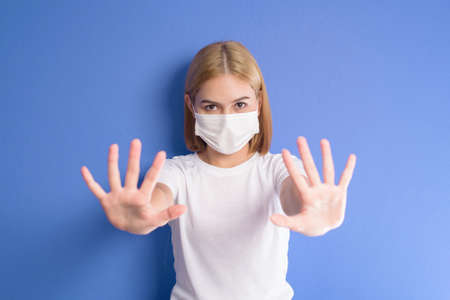 A portrait of short blonde hair woman wearing a surgical mask in studioの写真素材