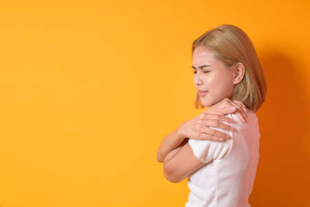 A portrait of short blonde hair woman with back pain in studioの写真素材