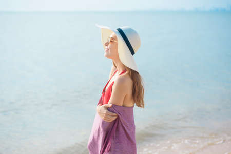 Portrait of beautiful woman in red swimsuit relaxing on the beachの写真素材