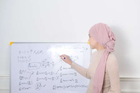 A muslim woman lecturer using laptop for lecturing online via internet. E-learning and telecommunication Conceptの写真素材