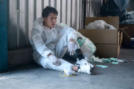 Worker in PPE exhausted and tried in Waste recycling plants during pandemic.