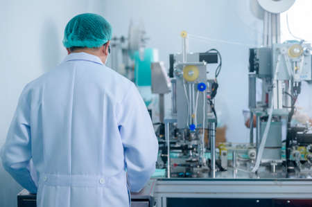 Workers producing surgical mask in modern factory,  protection and medical concept.の写真素材