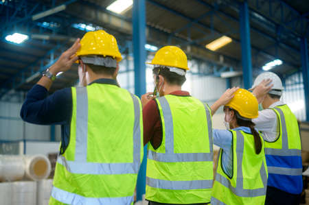 Engineer people are putting a protective helmet on  head in warehouseの写真素材