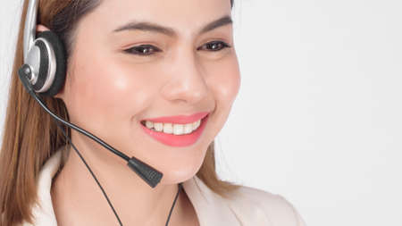 Customer service operator woman in suit wearing headset over white background studio