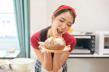 A young beautiful Asian woman is baking in her kitchen  , bakery and coffee shop businessの写真素材