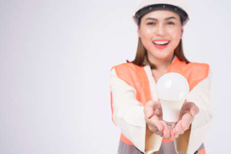 a woman engineer wearinng a protective helmet over white backgroud studioの写真素材