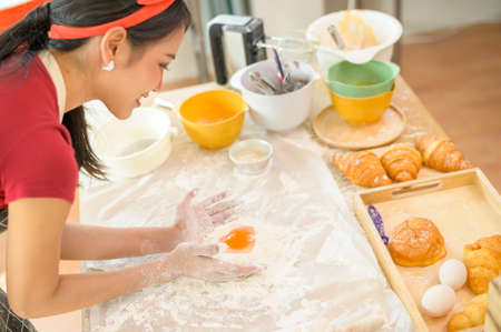 A young beautiful Asian woman is baking in her kitchen  , bakery and coffee shop businessの写真素材