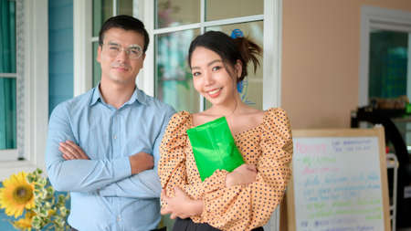 Business owners are analyzing business data , talking and smiling in modern shop