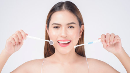 Young smiling woman holding invisalign braces in studio, dental healthcare and Orthodontic conceptの写真素材