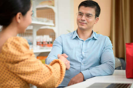 Business owners are analyzing business data , talking and smiling in modern shopの写真素材