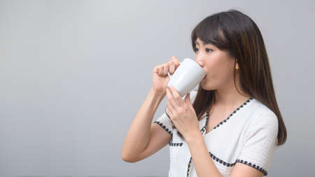 A portrait of young beautiful woman having a cup of coffeeの写真素材