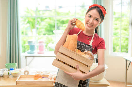 A young beautiful Asian woman is baking in her kitchen  , bakery and coffee shop businessの写真素材