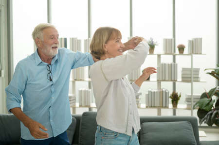 Happy Caucasian senior couple dancing at homeの写真素材