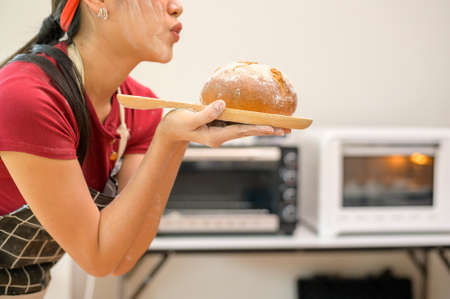 A young beautiful Asian woman is baking in her kitchen  , bakery and coffee shop businessの写真素材