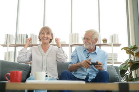 Happy Caucasian senior couple playing games at homeの写真素材