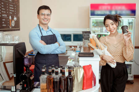 Portrait of cheerful baristas smiling in coffee shopの写真素材