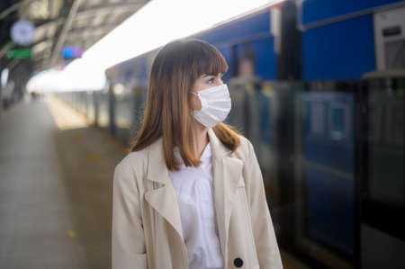 A young woman is wearing protective mask in metro