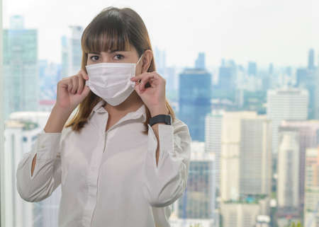 A Portrait of young beautiful Business Woman wearing a protective mask in modern office