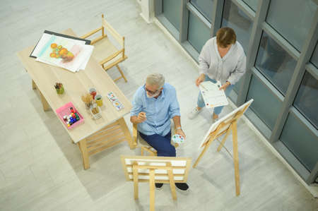 Senior caucasian couple painting and relaxing at homeの写真素材