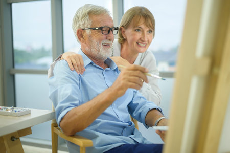 Senior caucasian couple painting and relaxing at homeの写真素材