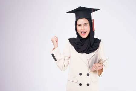 Young muslim woman graduated over white background studio.の写真素材