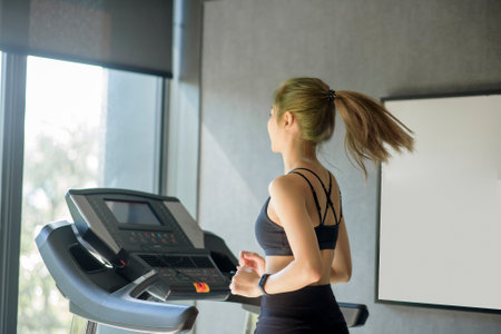 A beautiful woman running on the treadmill at gym, concept of healthy lifestyle, sports, training,...