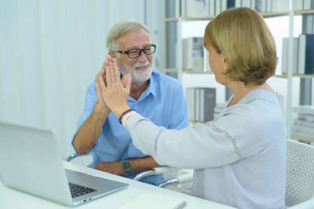 Senior caucasian business people making high five in modern office after finishing project