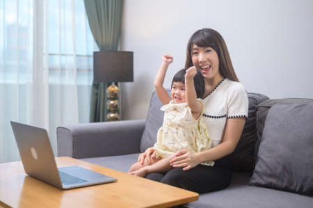 A happy mom and daughter relaxing at homeの写真素材