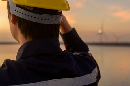 A male engineer wearing a protective helmet at sunset.の写真素材