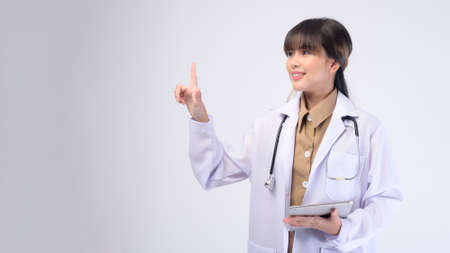 A young female doctor with stethoscope over white backgroundの写真素材