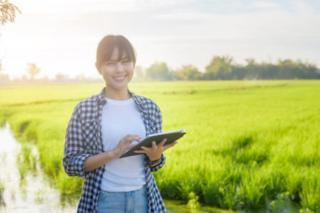 A young female smart farmer with tablet on field,High technology innovations and smart farmingの写真素材