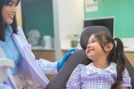 A little cute girl having teeth examined by dentist in dental clinic, teeth check-up and Healthy teeth conceptの写真素材