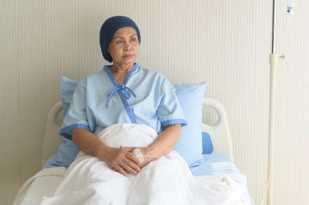 Portrait of senior cancer patient woman wearing head scarf in hospital, healthcare and medical...