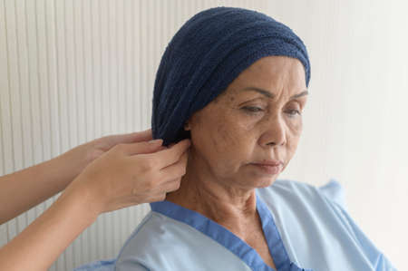 Portrait of senior cancer patient woman wearing head scarf in hospital, healthcare and medical...