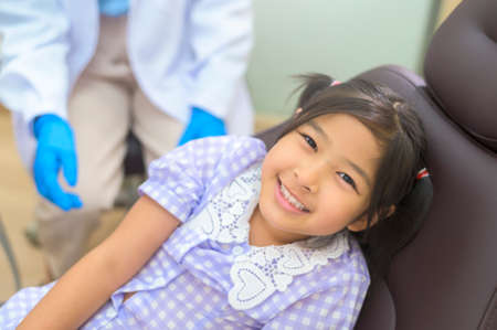 A little cute girl having teeth examined by dentist in dental clinic, teeth check-up and Healthy teeth conceptの写真素材