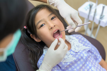 A little cute girl having teeth examined by dentist in dental clinic, teeth check-up and Healthy teeth conceptの写真素材