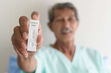 An Asian patient man is showing results of covid-19   test in hospitalの写真素材