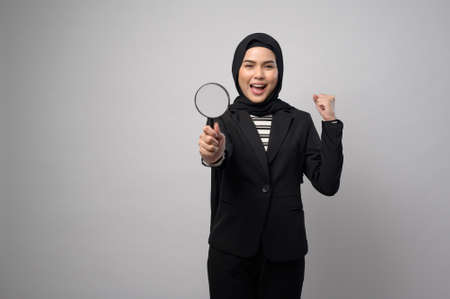 A muslim business woman holding Magnifier isolated on white backgroundの写真素材