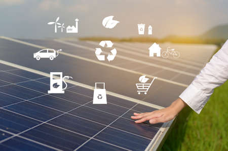 Close up of hand engineer touching with Photovoltaic Cell Farm or Solar Panels Field, eco friendly...