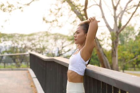 A young fitness woman in sportswear exercising in city park, Healthy and Lifestyles.