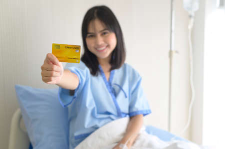 A young patient woman is holding credit card , admitting in hospital , Health care  conceptの写真素材