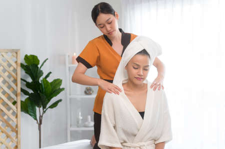 A young asian beautiful woman relaxing and enjoying massage, spa and beauty treatment conceptの写真素材