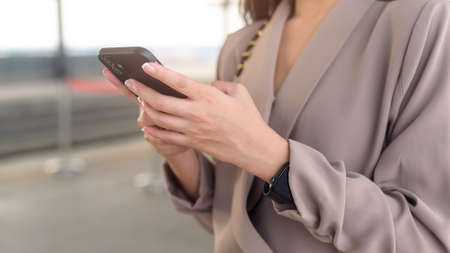 Close up business woman hand is using smartphone in modern city