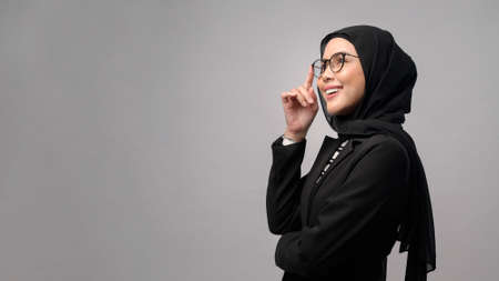 A beautiful muslim woman wearing glasses over white background studio