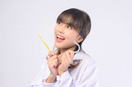A young female dentist smiling over white background studio