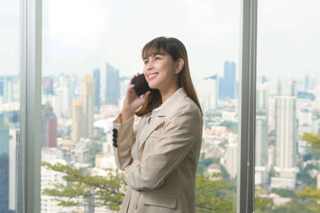 A young beautiful Business Woman using smart phone in modern office